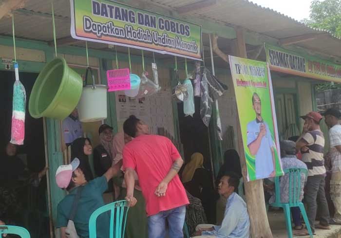 TARIK PERHATIAN: Suasana TPS yang membagikan undian perabotan rumah tangga untuk meningkatkan partisipasi pemilih.