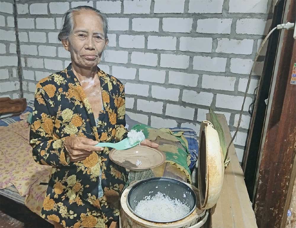 MEMASAK PERTAMA DENGAN LISTRIK: Samijah memasak nasi dengan rice cooker setelah rumahnya tersalur listrik.