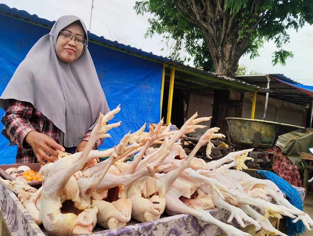 HARGA NAIK: Salah satu pedagang daging ayam di Pasar Bongkaran Tuban saat berjualan, Minggu (25/1).