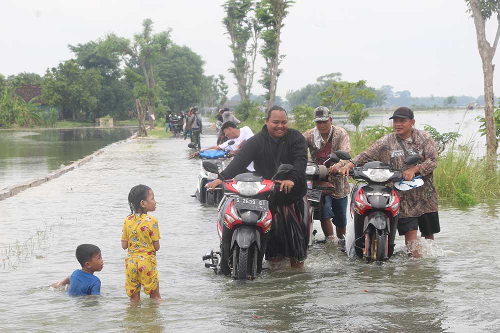 TERENDAM: Jalan penghubung antara Desa Kanorejo dan Desa Karangtinoto, Kecamatan Rengel terendam air luapan Sungai Bengawan Solo, Senin (11/3).