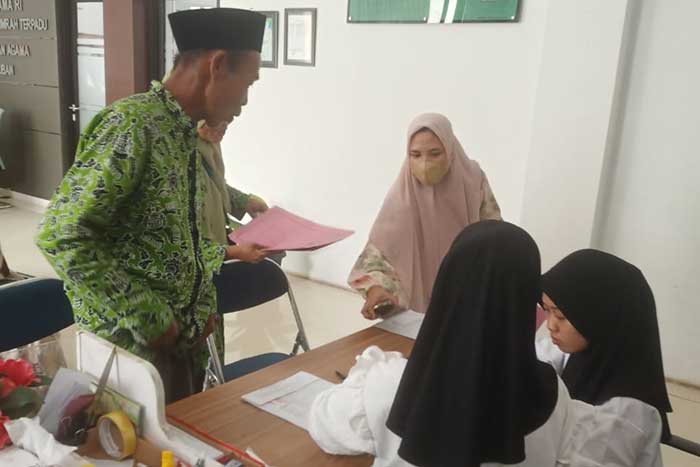 MELUNASI: CJH di kantor pusat layanan haji menyerahkan berkas setelah melakukan pelunasan di bank.