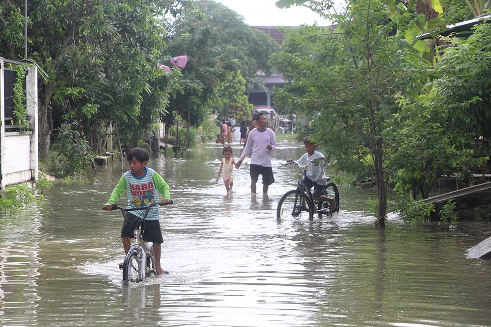 SURUT: Akses jalan yang sebelumnya terendam air luapan Sungai Bengawan Solo, Jumat (15/3) sudah bisa dilintasi kendaraan bermotor.
