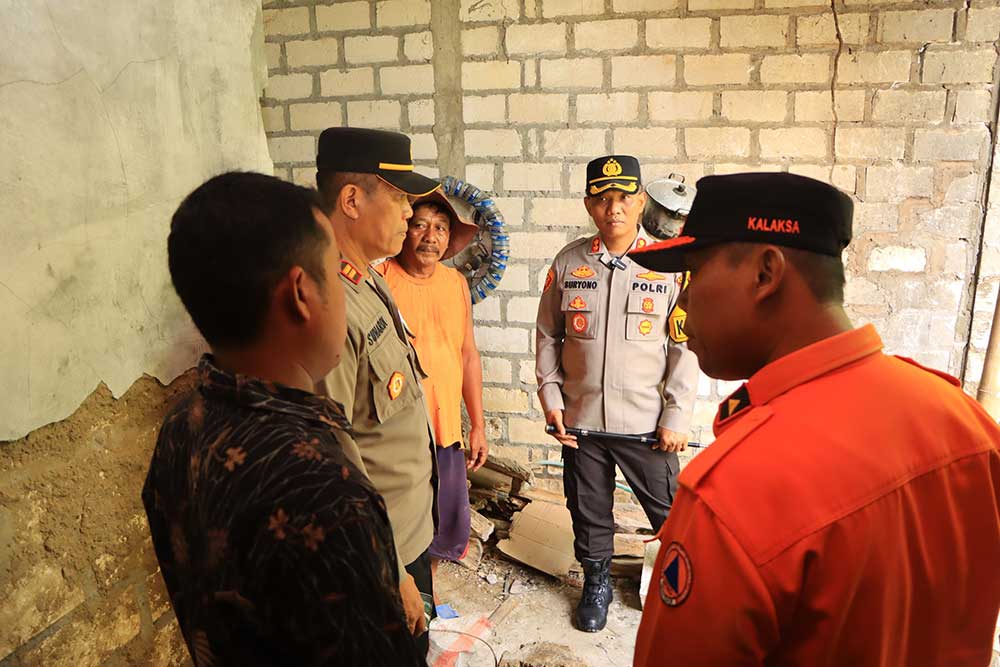 TINJAU KERUSAKAN: Petugas BPBD Tuban bersama Polres Tuban lakukan pengecekan rumah korban yang terdampak gempa.