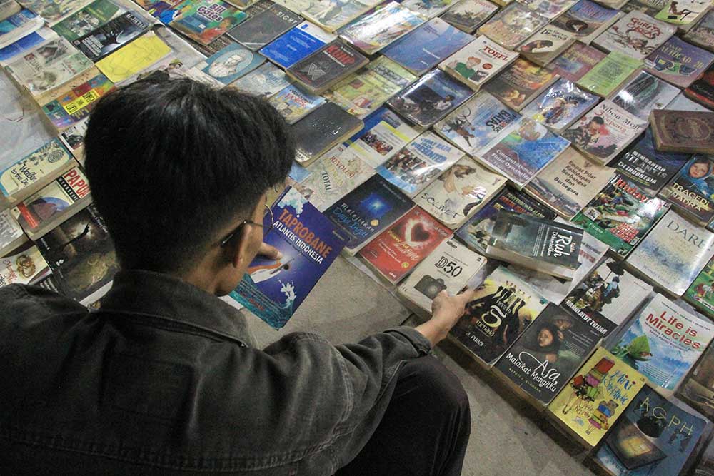 BACA BUKU GRATIS: Komunitas Apel Wetan buka stan baca buku gratis di GOR Rangga Jaya Anoraga Tuban, Minggu malam (31/3).