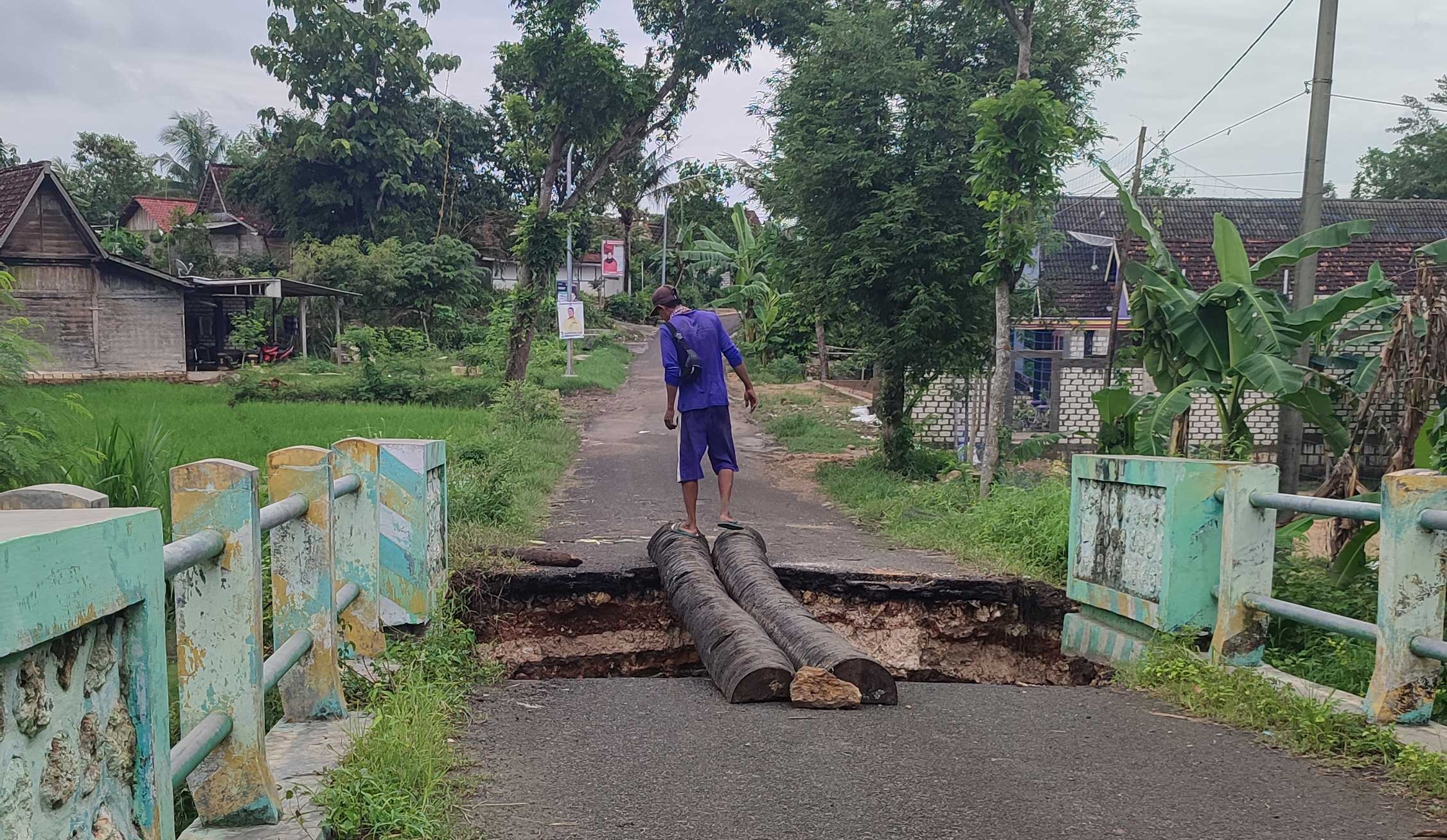MENGKHAWATIRKAN: Warga Desa Dikir masih nekat melintas sebelum dibangun jembatan darurat.