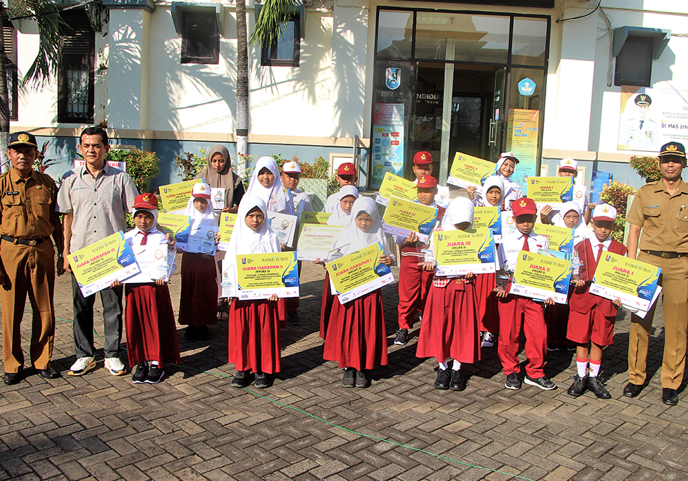 SELAMAT BERPRESTASI : Kepala Dinas Pendidikan (Disdik) Tuban, Abdul Rakhmat bersama Project Officer Event Jawa Pos Radar Tuban, Dwi Setiyawan menyerahkan trofi kepada para juara Festival Literasi Nume