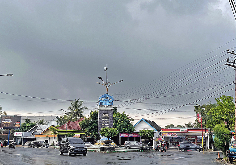 BASAH KUYUP: Tugu di pertigaan Pakah, yang diguyur hujan, kemarin (9/6).