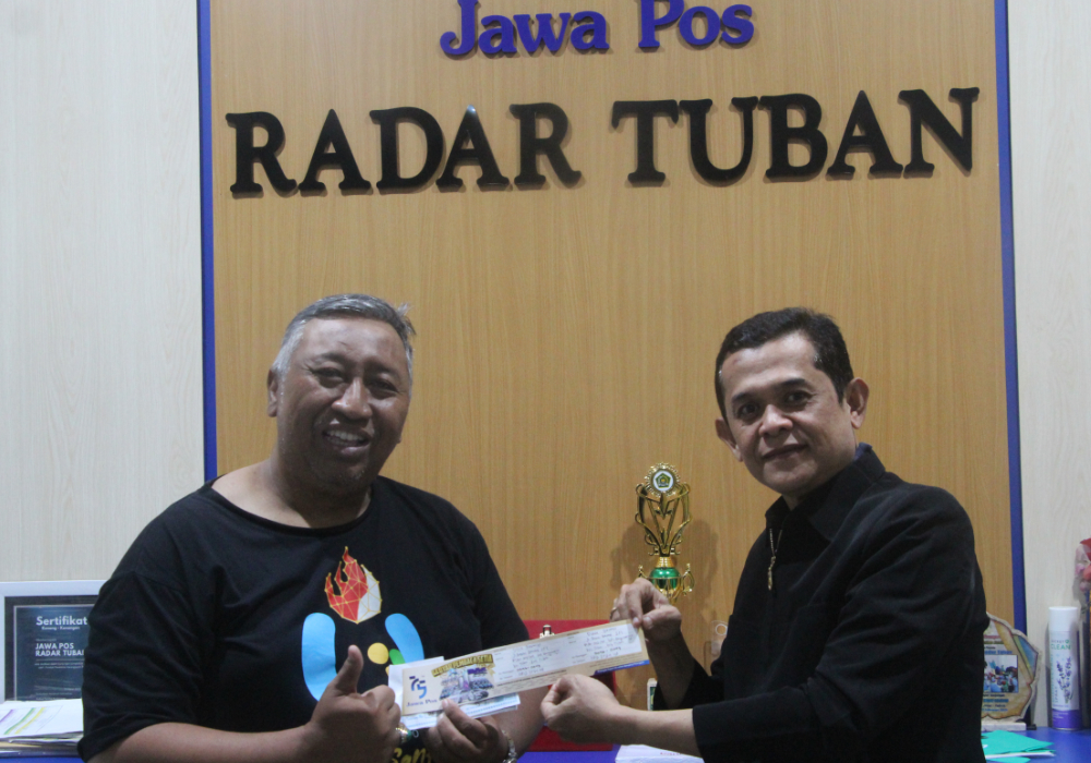 SEMOGA BERUNTUNG: Didik Purwanto menyerahkan kupon undian yang diterima langsung oleh Pimred Jawa Pos Radar Tuban Dwi Setiyawan.