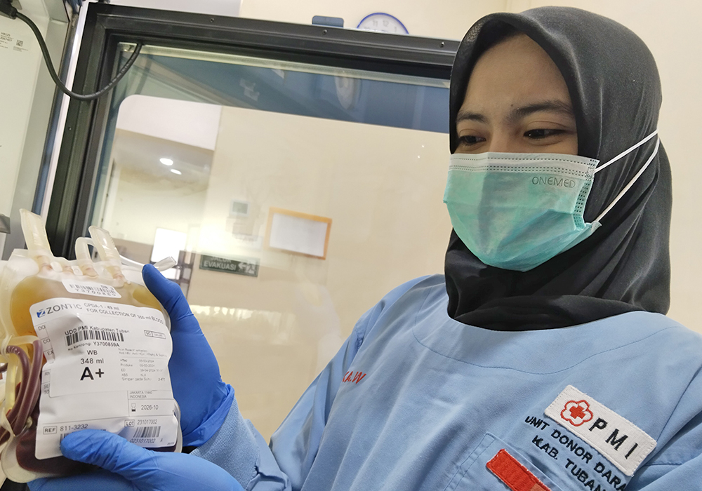 PASTIKAN AMAN: Salah satu pegawai PMI Tuban saat melihat pasokan kantong darah yang tersedia.