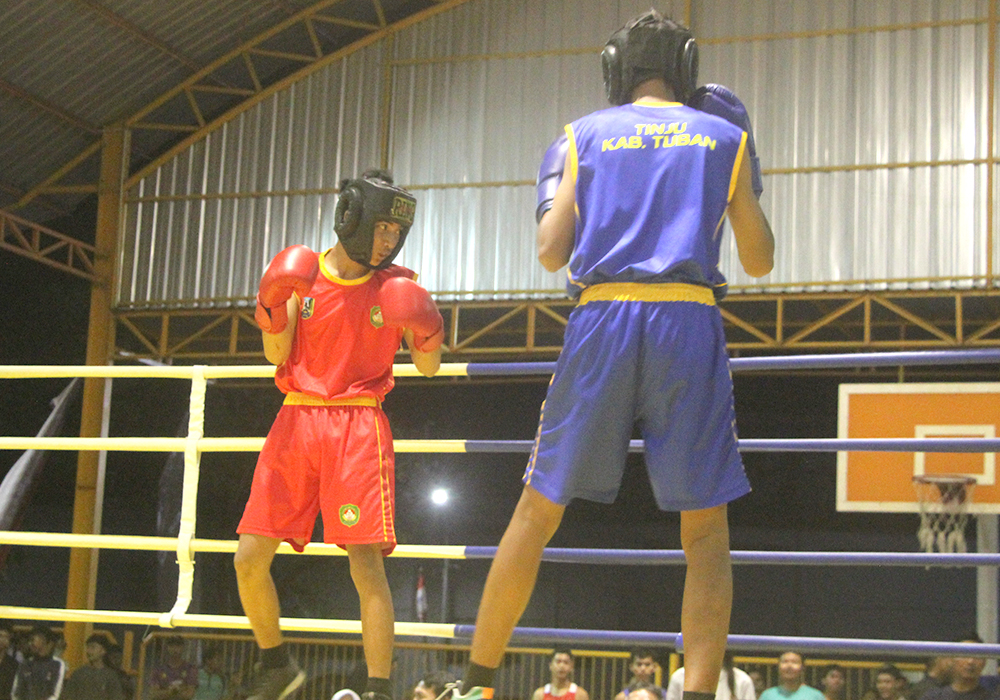 Dua atlet tinju bertarung di atas ring merebutkan medali emas kelas 51 kg di kompleks GOR Rangga Jaya
