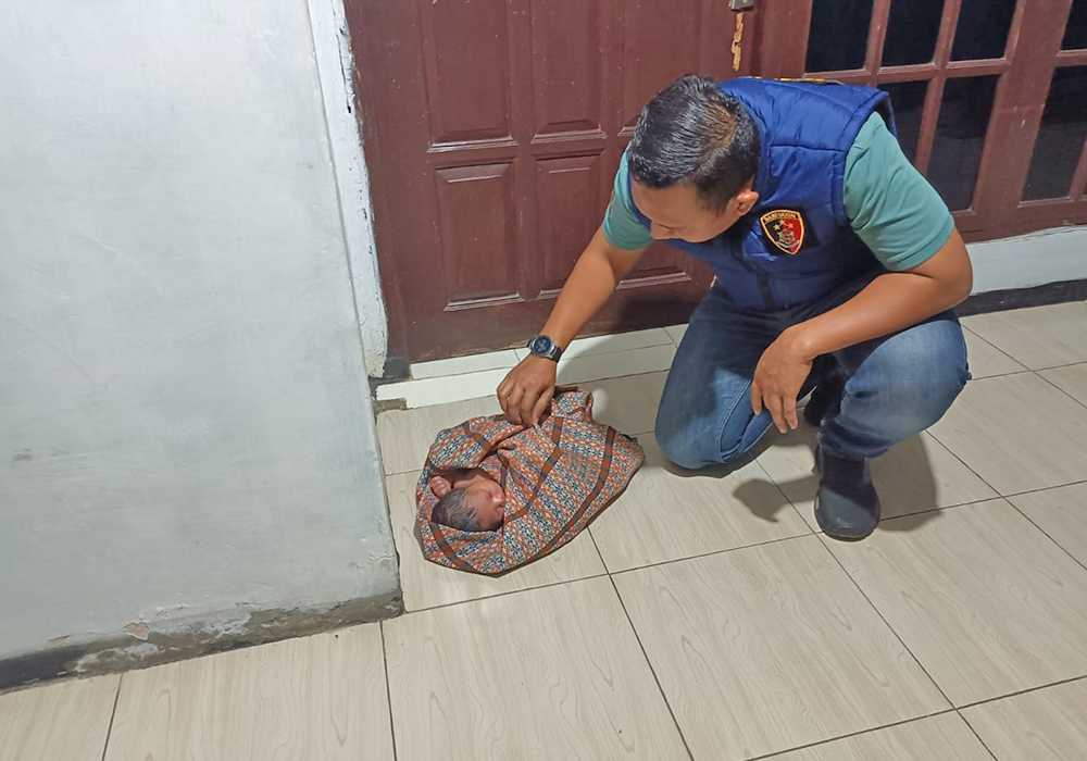 TERLANTAR: Polisi saat mengevakuasi bayi berusia tiga hari yang terlantar di salah satu rumah warga Desa Bektiharjo, Kecamatan Semanding, Rabu (10/7).