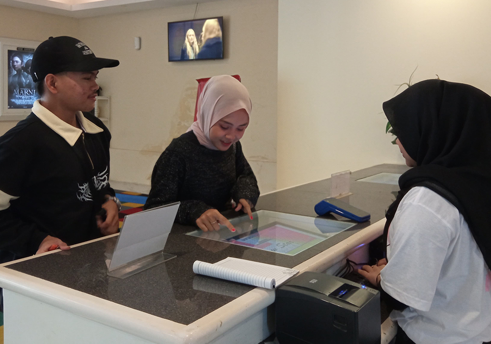 CARI HIBURAN: Salah satu pengunjung bioskop saat memilih tempat duduk di dalam teater.