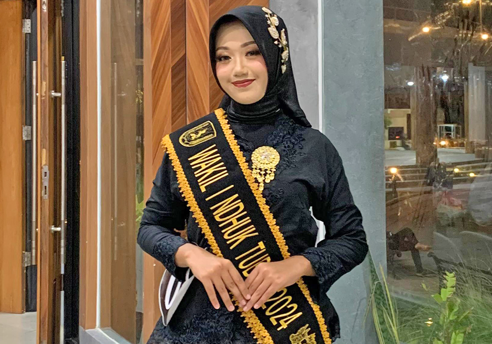 CANTIK: Irma yang berpose mengenakan pakaian dengan slempang prestasi kebanggaannya.
