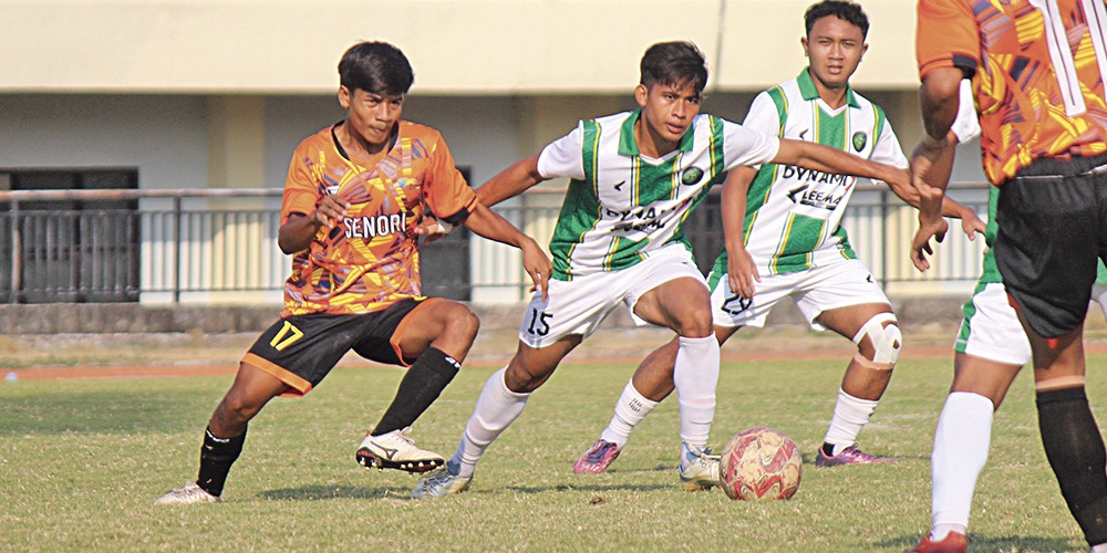 BERTANDING: Pemain tim kecamatan Tambakboyo (hijau putih) saat memenangkan duel dengan pemain tim Kecamatan Senori di babak delapan besar Porkab VIII Tuban 2024 cabor sepak bola.
