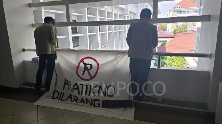 Mahasiswa saat memasang baliho bertuliskan Pratikno yang dilarang masuk UGM.