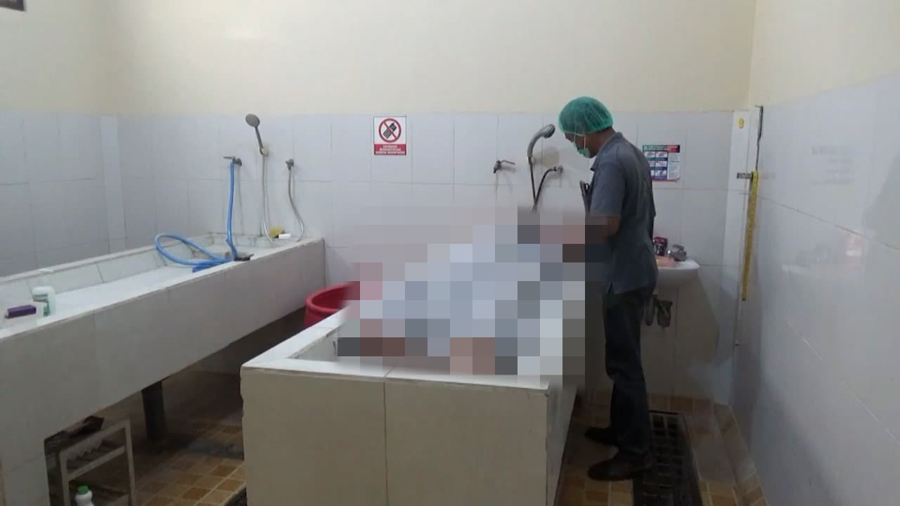 Petugas saat mengotopsi jenazah karyawan PT Pertamina yang meninggal mendadak di Front One King Hotel Tuban.