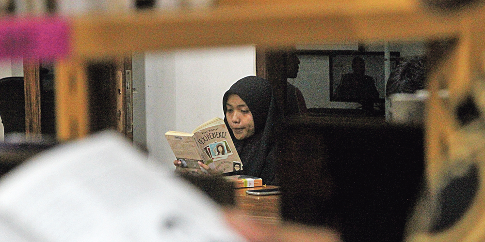 Para pengunjung yang membaca buku di perpustakaan umum daerah (perpusda).