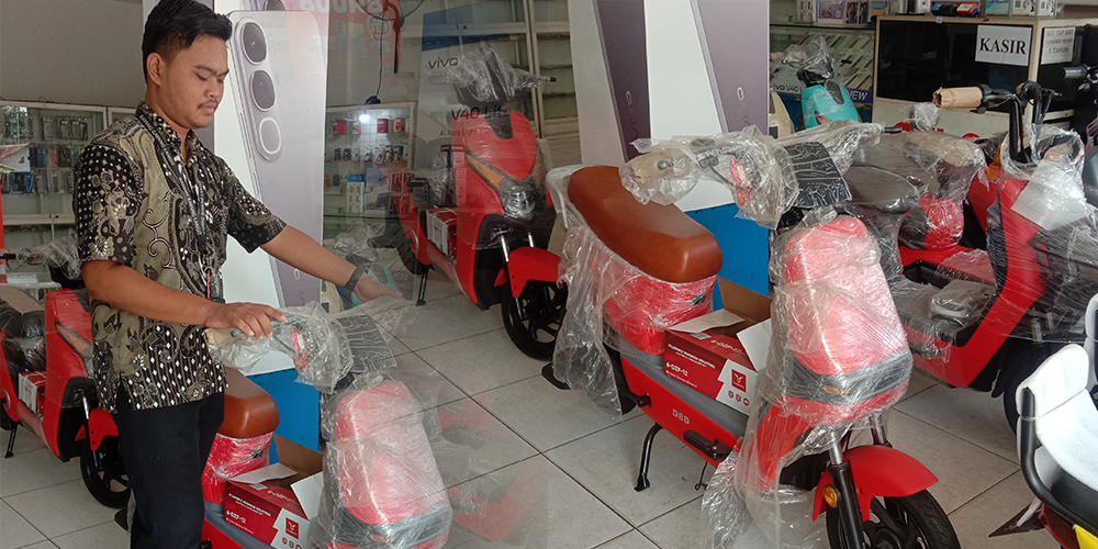 Ari Setyawan tengah memperhatikan fasilitas sepeda listrik yang penjualannya mulai menurun.