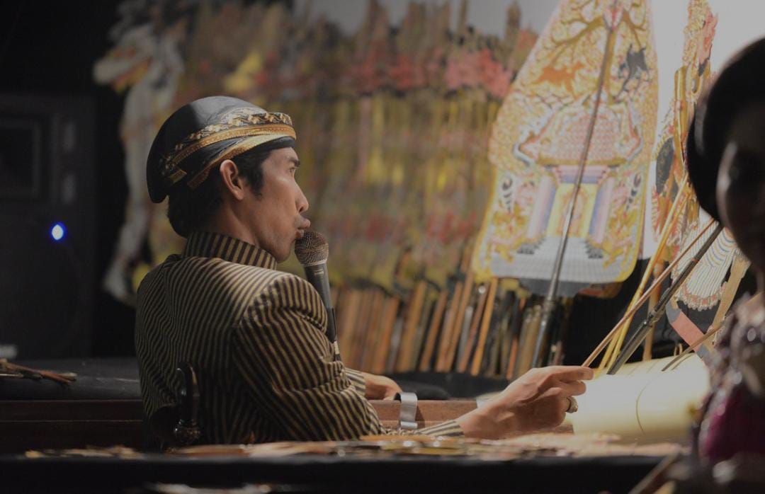 Ilustrasi dalamg memainkan wayang.