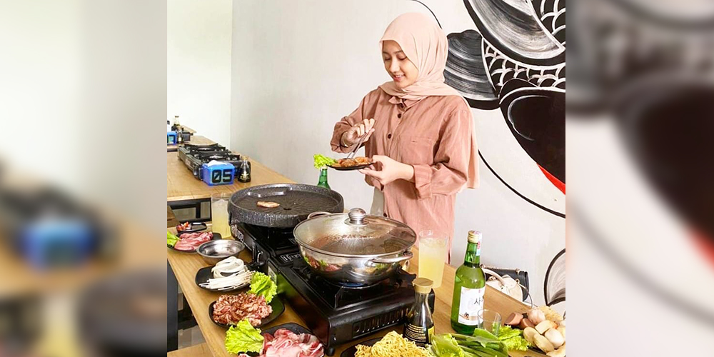 Seorang konsumen Gyuniku tampak asik membakar daging di atas grill pan untuk merayakan malam pergantian tahun, Rabu (1/1).