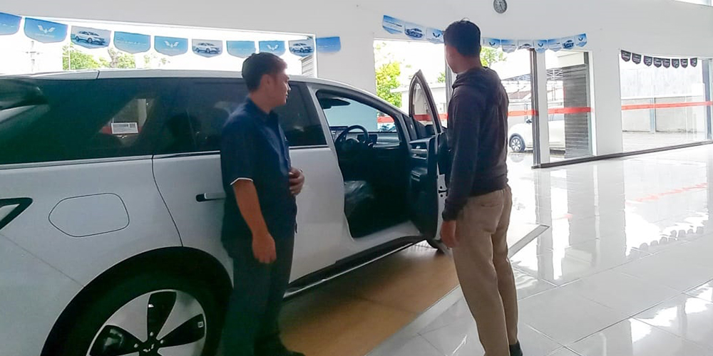 Sales mobil Wuling Tuban menjelaskan spesifikasi mobil merek Wuling kepada konsumen.