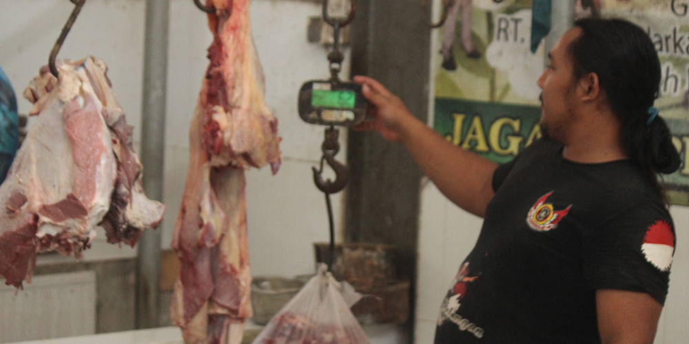 Penjual daging sapi di Pasar Baru Tuban menunggu pembeli datang di kiosnya, Selasa (28/1).