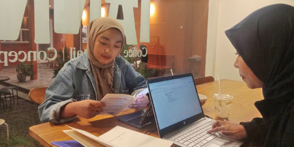 Pengunjung kafe tanna terlihat konsentrasi membaca buku yang ada di kafe tersebut.