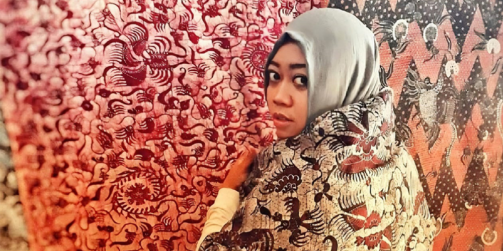 Radhika berselimut dengan kain batik hasil karya tangan luwesnya.