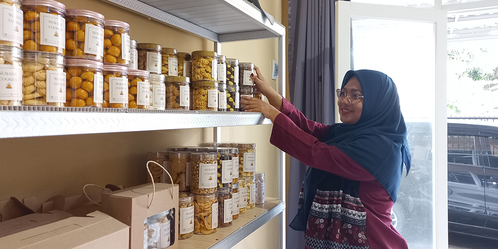 Adhelia pemilik usaha Nuranie Cookies sedang melakukan checking stok pesanan kue kering untuk pelanggannya.