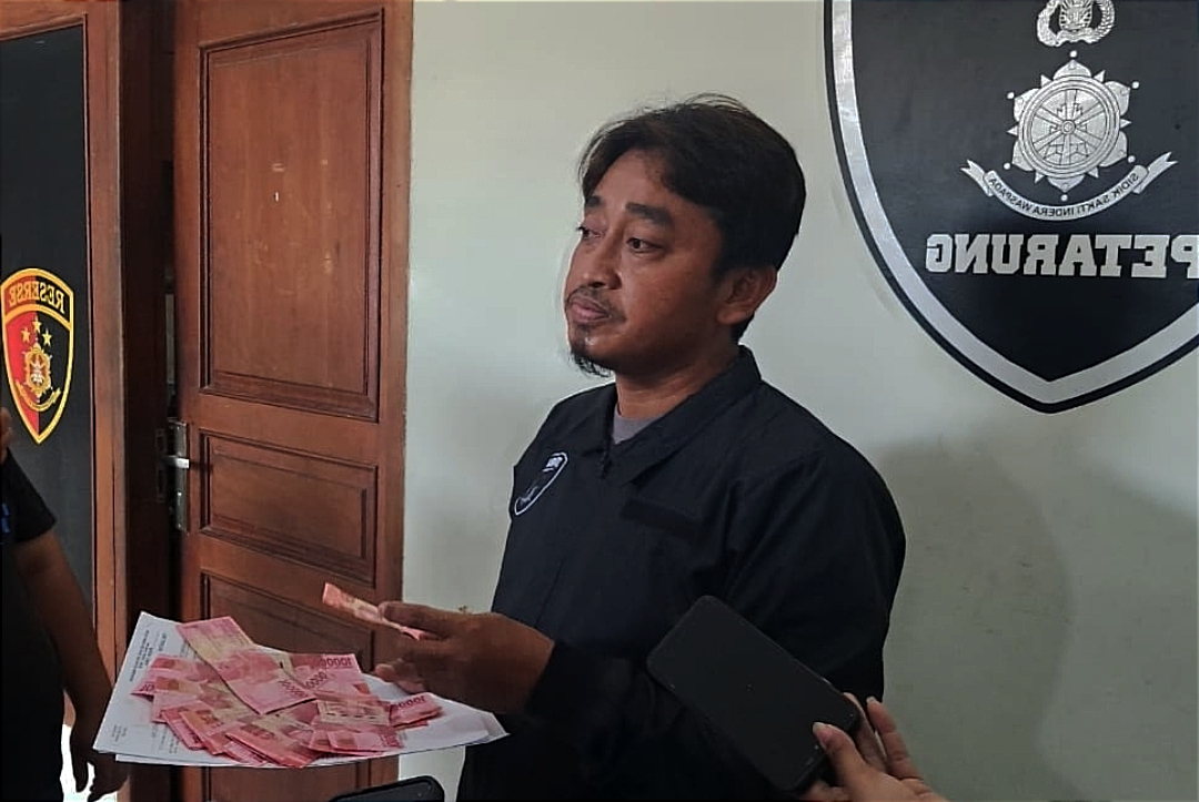 Kanit Jatanras Ipda M. Rudy saat membeberkan barang bukti uang palsu dari tangan tersangka.