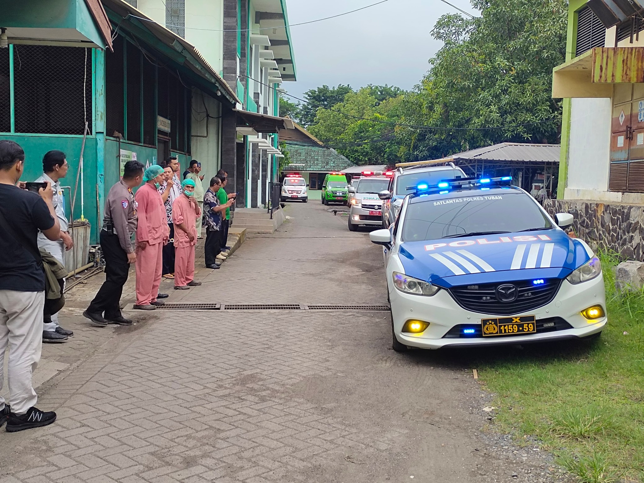 Petugas kepolisian mengantar korban kecelakaan pengiring umrah dari Desa Tuwiri Wetan, Kecamatan Merakurak Tuban.