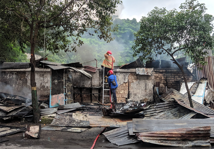 Petugas Damkar Tuban melakukan pemadaman kobaran api yang membakar warung di Jalan M. Yamin Tuban pada Februari lalu.