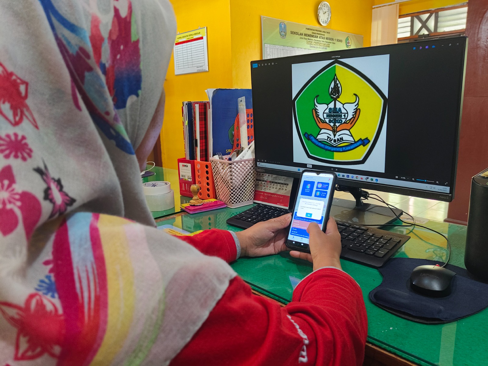 Salah satu guru SMAN 1 Soko tengah memantau kulitas udara melalui apliksi Sigma.