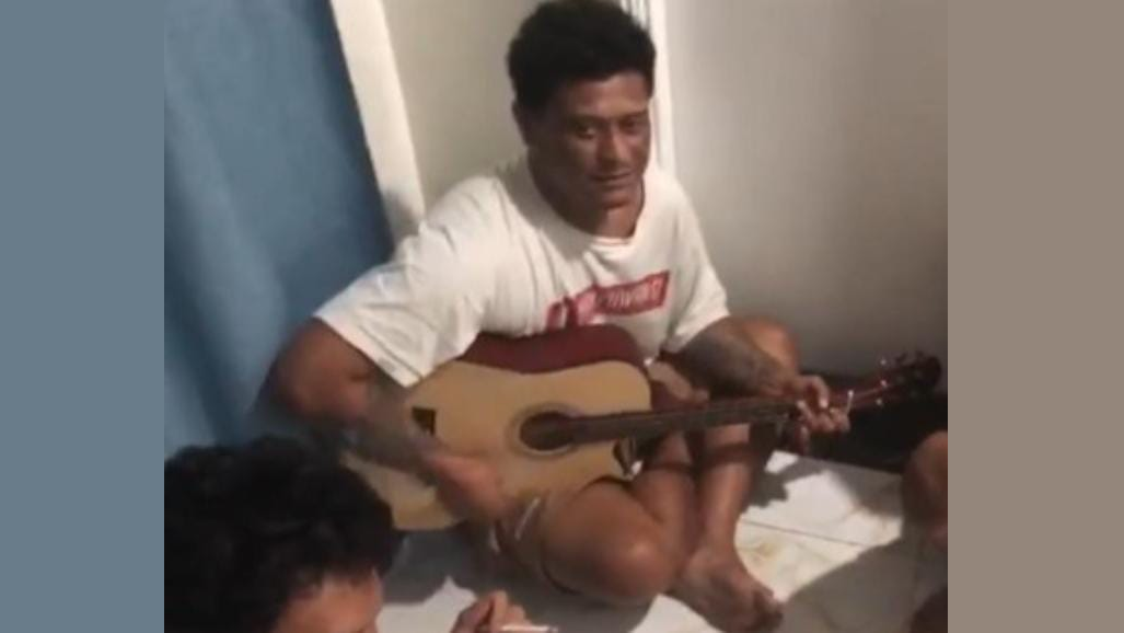 Tangkapan layar sebuah video yang memperlihatkan Rizal tengah memainkan gitar, sebelum dirinya meninggal.