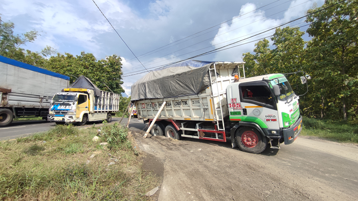 Truk PT Semen Indonesia Logistik (Silog) berpengangkut muatan material logistik terjerembab aspal yang amblas di JLS