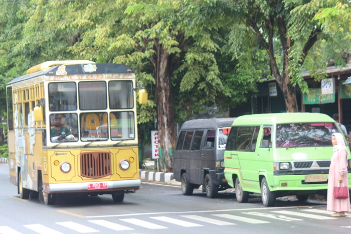 Bus Si Mas Ganteng saat melintas beriringan dengan MPU di Jalan dr. Wahidin Sudiro Husodo. Para sopir MPU mengeluh karena banyak penumpang umum yang beralih ke Bus Si Mas Ganteng