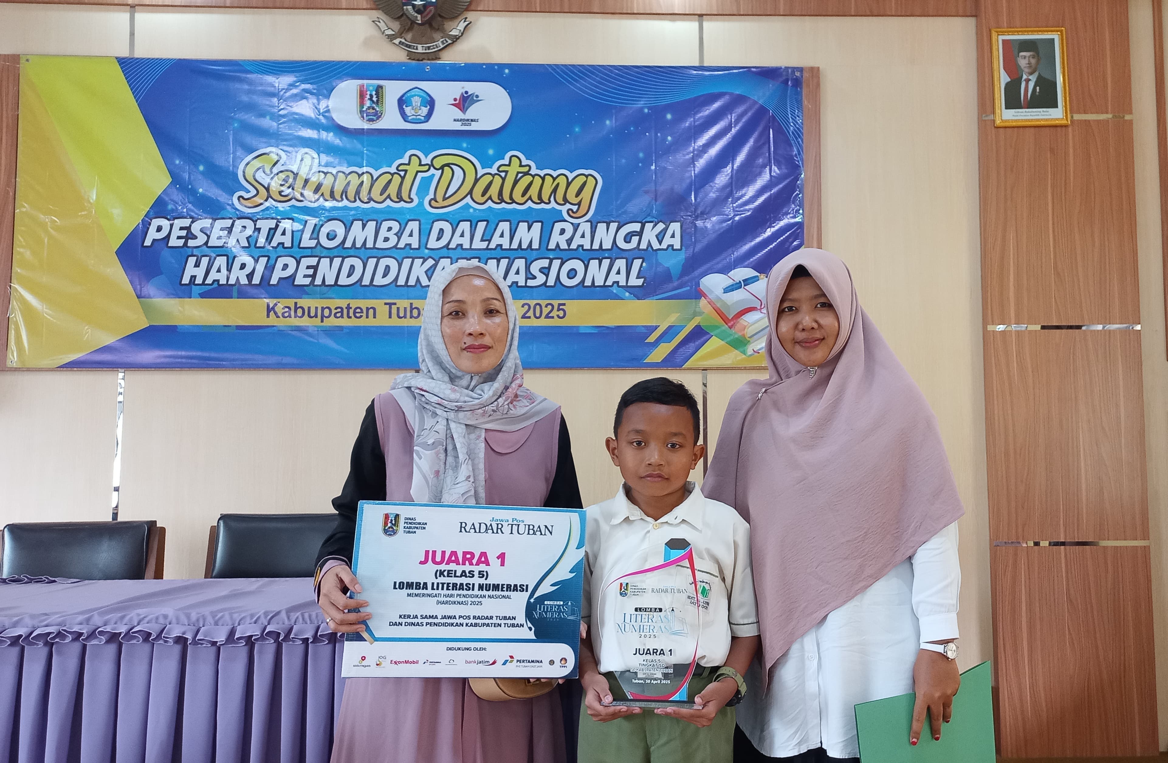 Azam didampingi ibu dan gurunya menerima piala juara 1 Lomba Literasi Numerasi kelas 5 yang diadakan Jawa Pos Radar Tuban, Rabu (28/5).