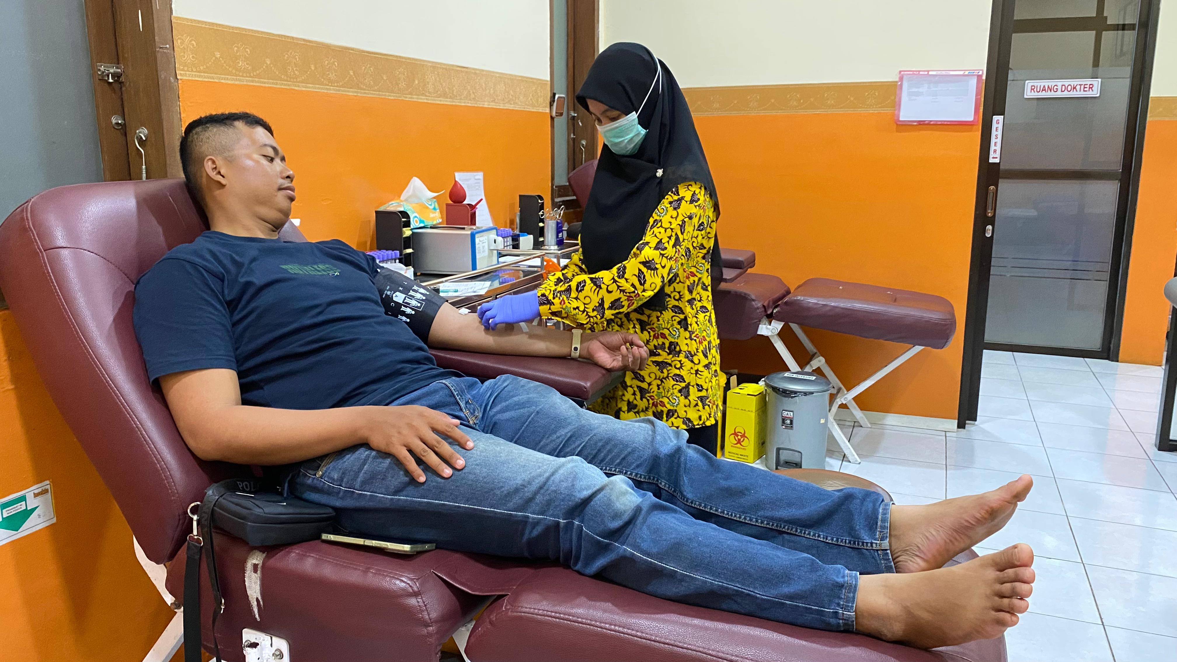 Salah seorang petugas UDD PMI Tuban sedang melakukan tindakan pengambilan darah pada seorang pendonor.