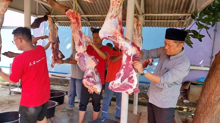 IKUT TURUN TANGAN:Senior Manager Operation and Manufacturing (SMOM) PT TPPI Tombayasin Rusdi memotong daging hewan kurban yang akan diserahkan ke warga sekitar.