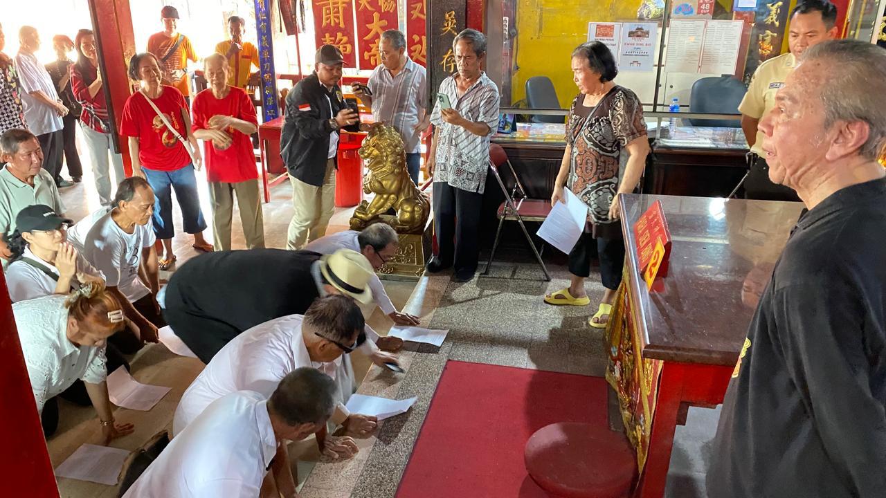 Tjing Hai, karyawan pengelola kelenteng (kanan) mengawasi Tjong Ping yang bersama pengurus-penilik terpilih TITD Kwan Sing Bio Tuban menggelar ikrar di altar kelenteng pada Minggu (8/6).