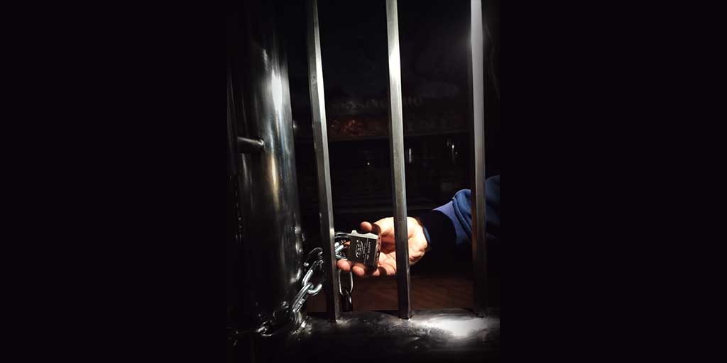 Kondisi pintu gerbang utama TITD Kwan Sing Bio Tuban yang dirantai dan digembok. Seluruh lampu dan lilin dimatikan.
