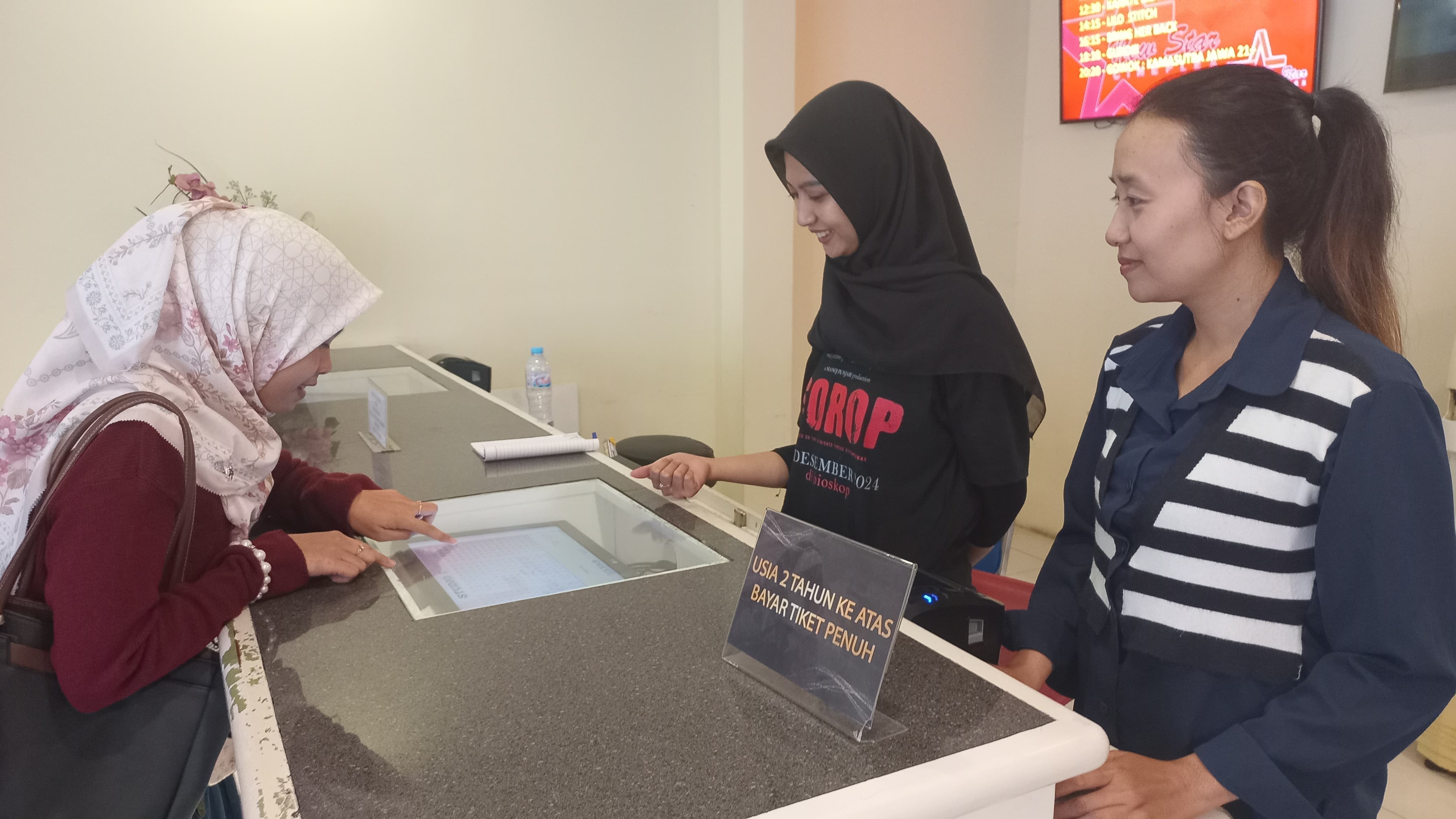 Staf kasir NSC Tuban tengah melayani penonton dalam memilih seat dan membeli tiket.