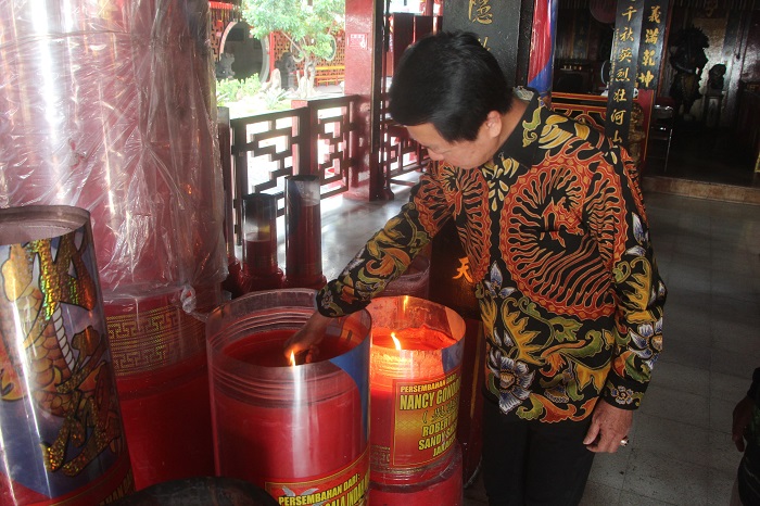 Pepeng Putra Wirawan menyalakan salah satu dari puluhan lilin di TITD Kwan Sing Bio Tuban setelah membuka gembok gerbang, Rabu (11/6) pagi.