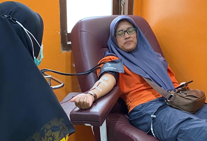 Petugas UDD PMI mengambil darah pendonor di ruang pengambilan darah.