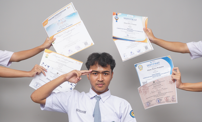 Adam berpose dengan berbagai sertifikat kompetisi matematika yang berhasil didapatkannya.