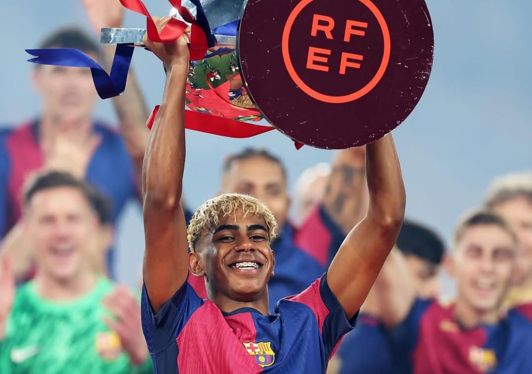 Lamine Yamal saat angkat trofi bersama Barcelona.