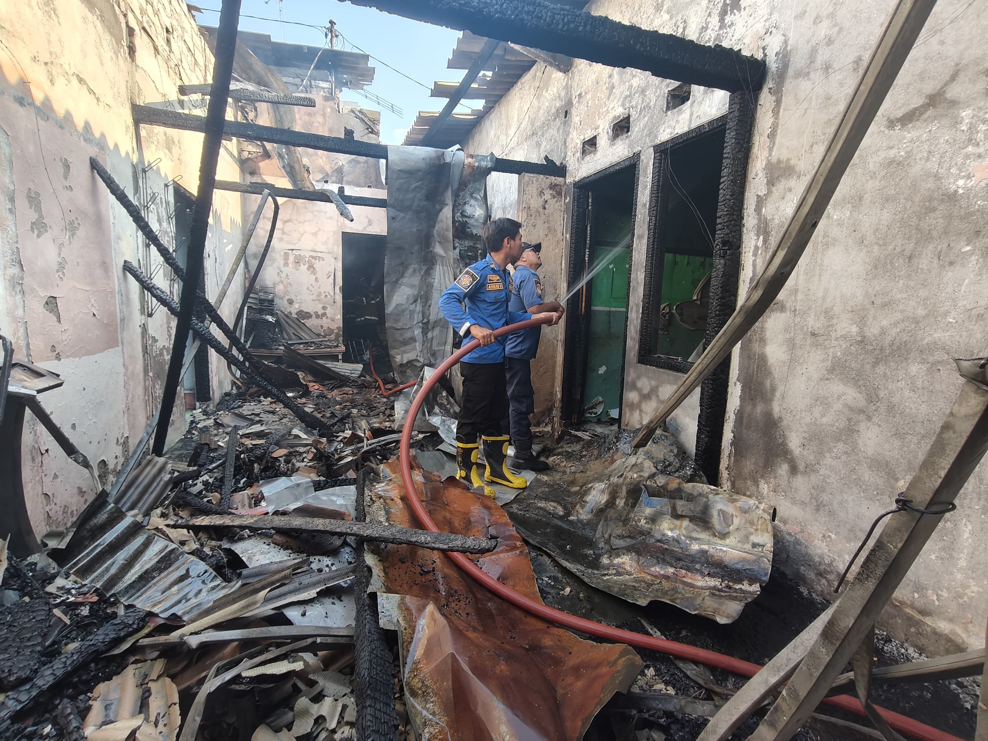 Petugas Damkar Tuban melakukan pemadaman api yang melalap bangunan rumah di wilayah Kelurahan Kebonsari, Kecamatan Tuban, kemarin (14/7).