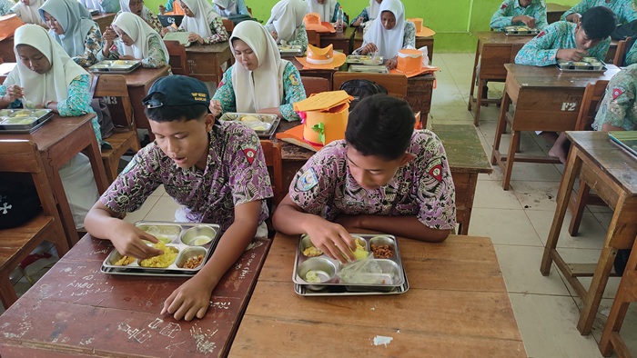 Siswa kelas 10 di SMKN 1 Tambakboyo makan siang bersama dengan menu MBG, Kamis (17/7).