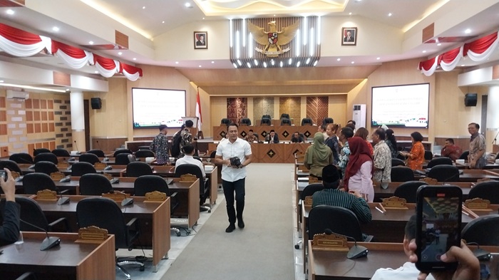 Pengacara Wiwit, Nang Engki Anom Suseno berjalan meninggalkan rapat dengar pendapat yang difasilitasi Komisi II DPRD Tuban kemarin (30/7).