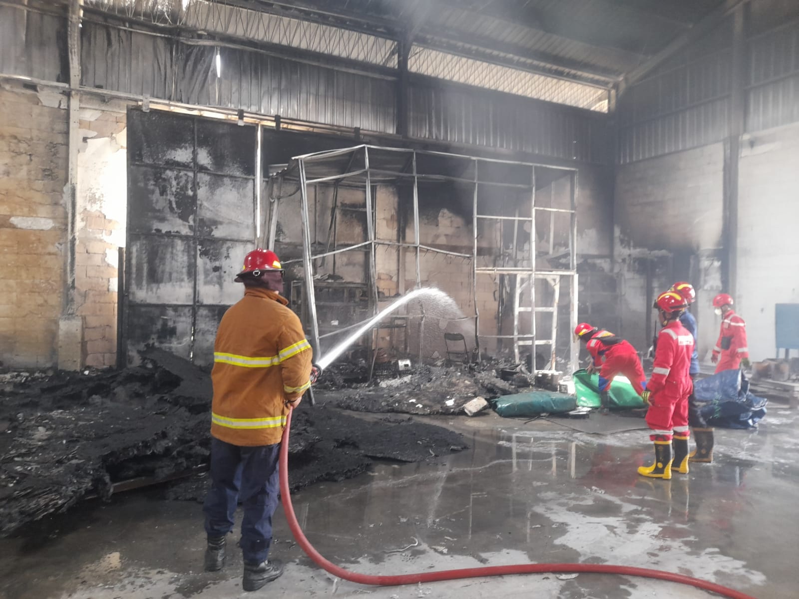 Petugas Damkar Tuban melakukan pemadaman api yang membakar gudang penyimpanan barang di CV Sumber Pangan Gemilang Desa Minohorejo